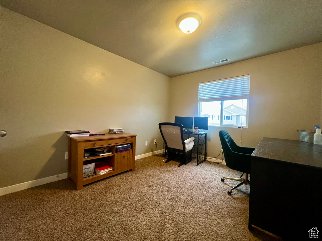Office area with carpet flooring, visible vents, and baseboards