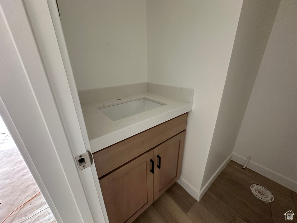 Bathroom with baseboards, wood finished floors, and vanity