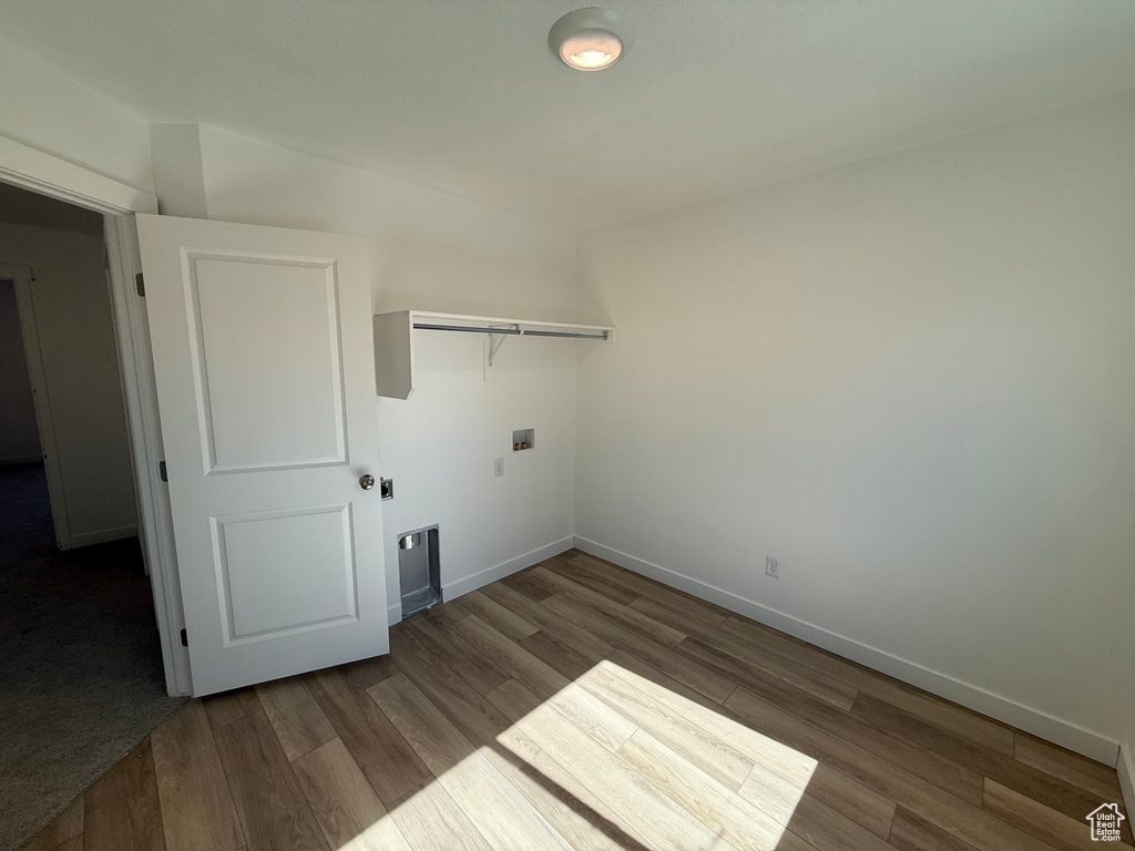 Washroom with wood finished floors and washer hookup
