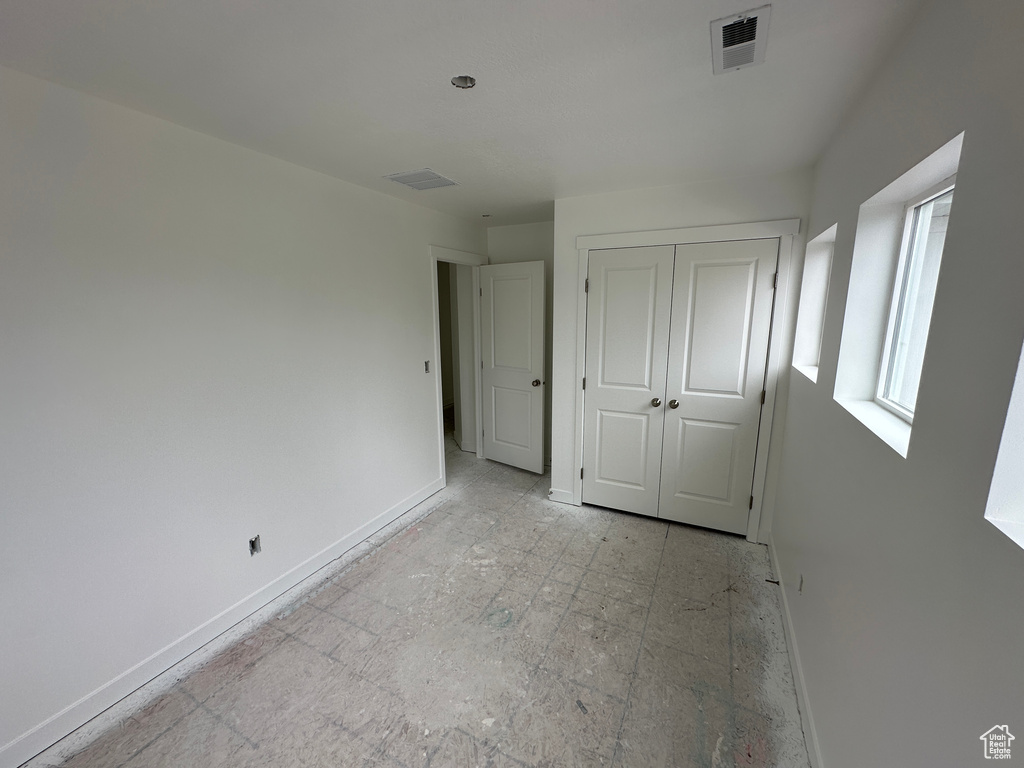Unfurnished bedroom with baseboards, a closet, and visible vents
