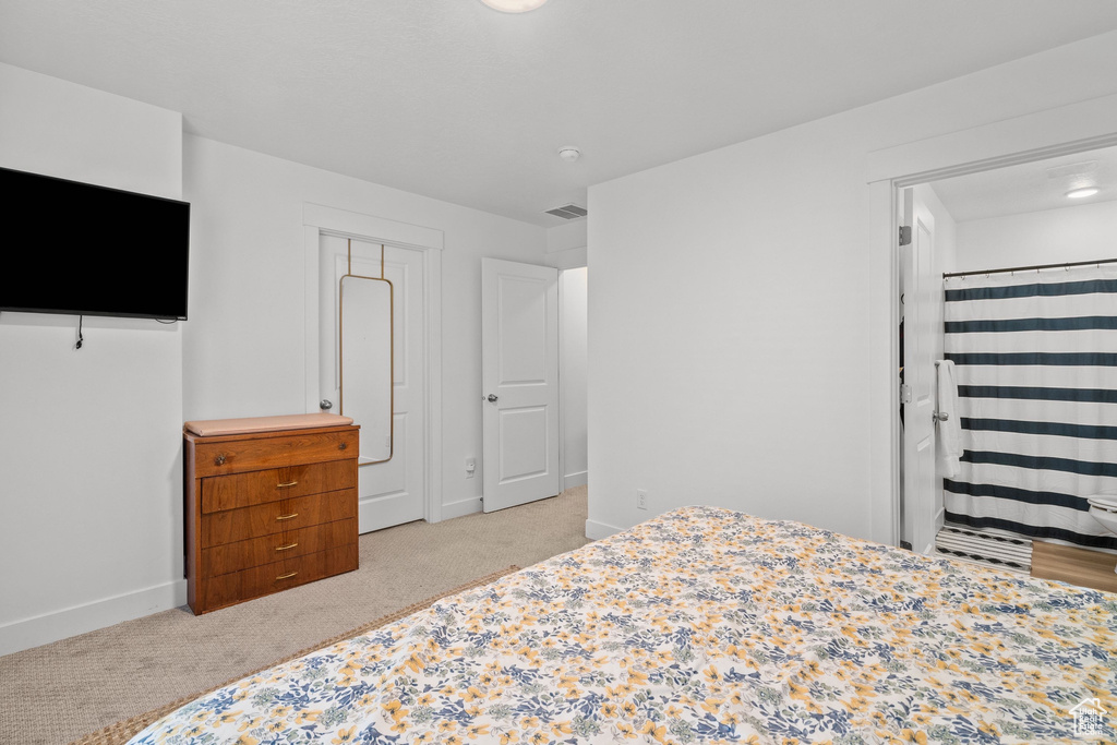 Bedroom with baseboards, visible vents, and light colored carpet