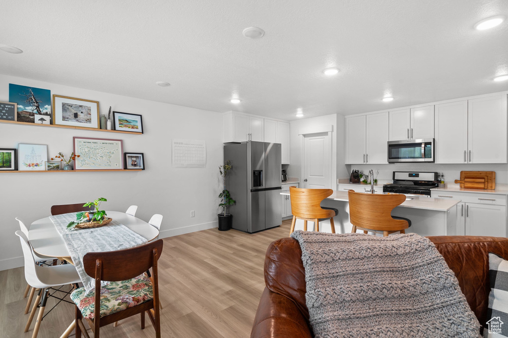 Kitchen with recessed lighting, light countertops, white cabinets, and appliances with stainless steel finishes