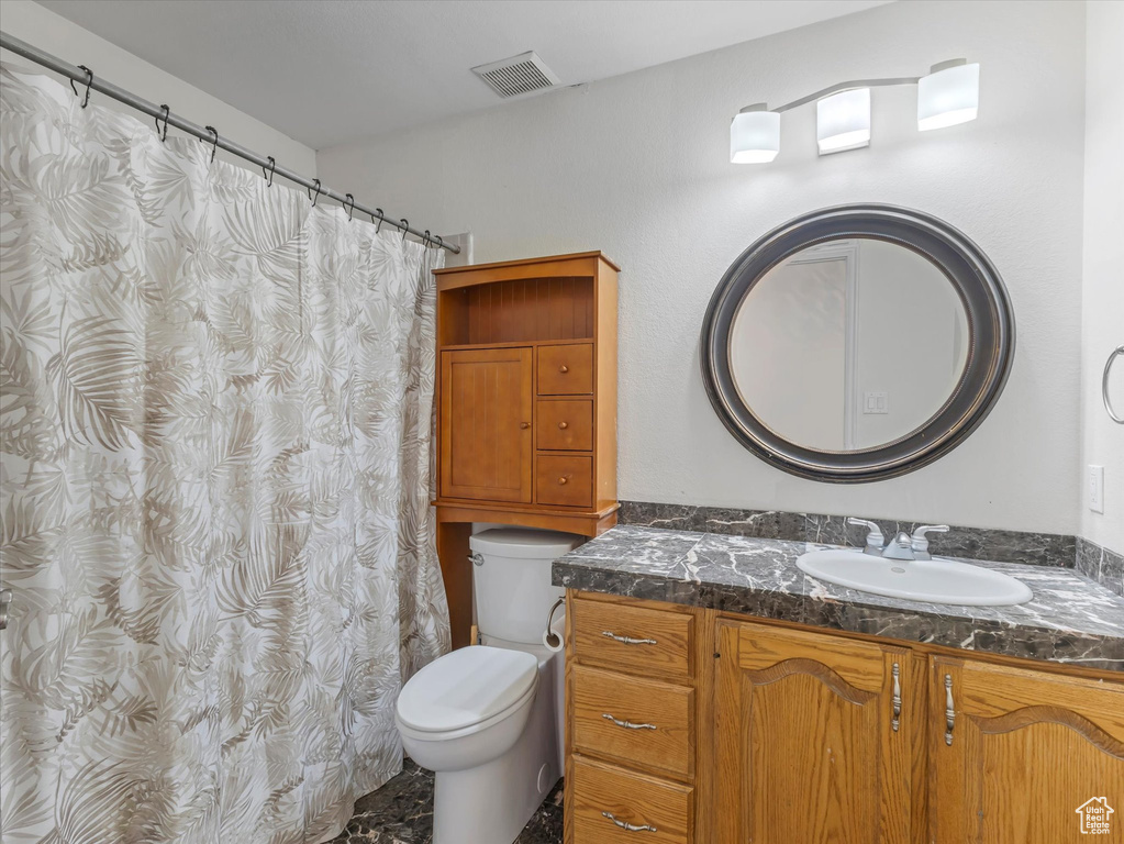 Full bath featuring vanity, toilet, and visible vents