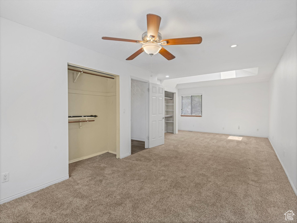 Unfurnished bedroom with baseboards, a skylight, recessed lighting, and carpet