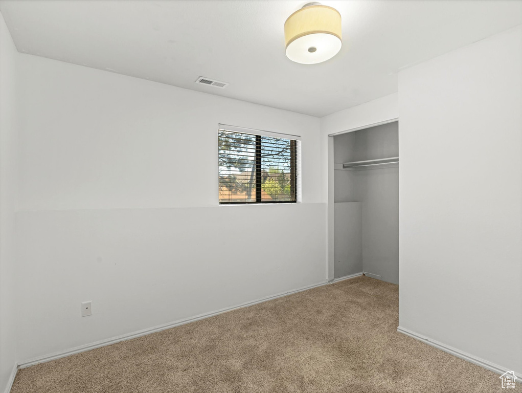 Unfurnished bedroom featuring a closet, visible vents, baseboards, and carpet floors