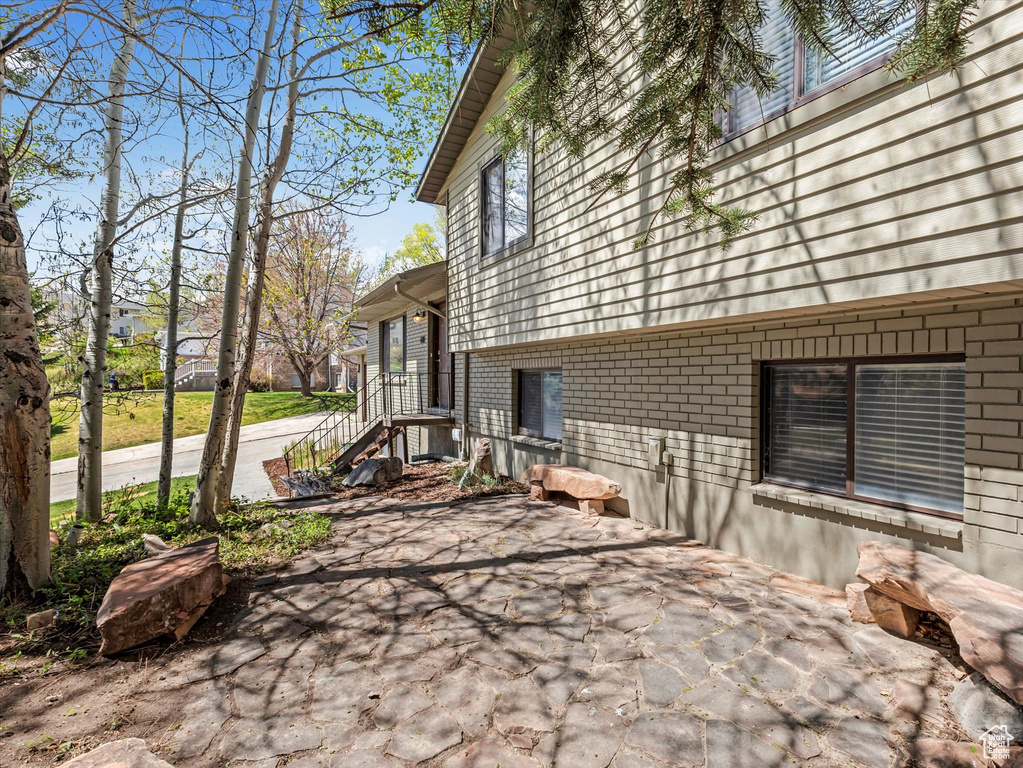 View of side of property with a patio area and brick siding