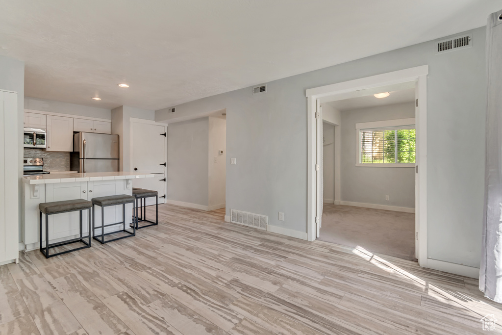 Living room with baseboards, visible vents, and recessed lighting