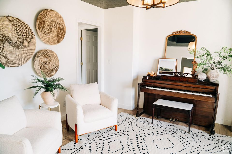 Sitting room with a notable chandelier, baseboards, and wood finished floors