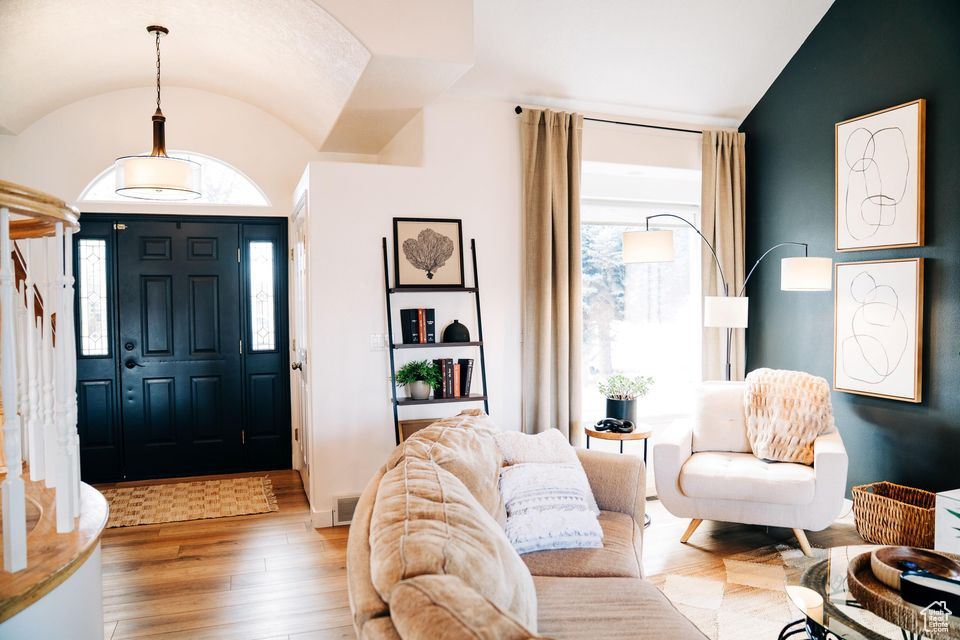 Entryway featuring vaulted ceiling, a wealth of natural light, and wood finished floors