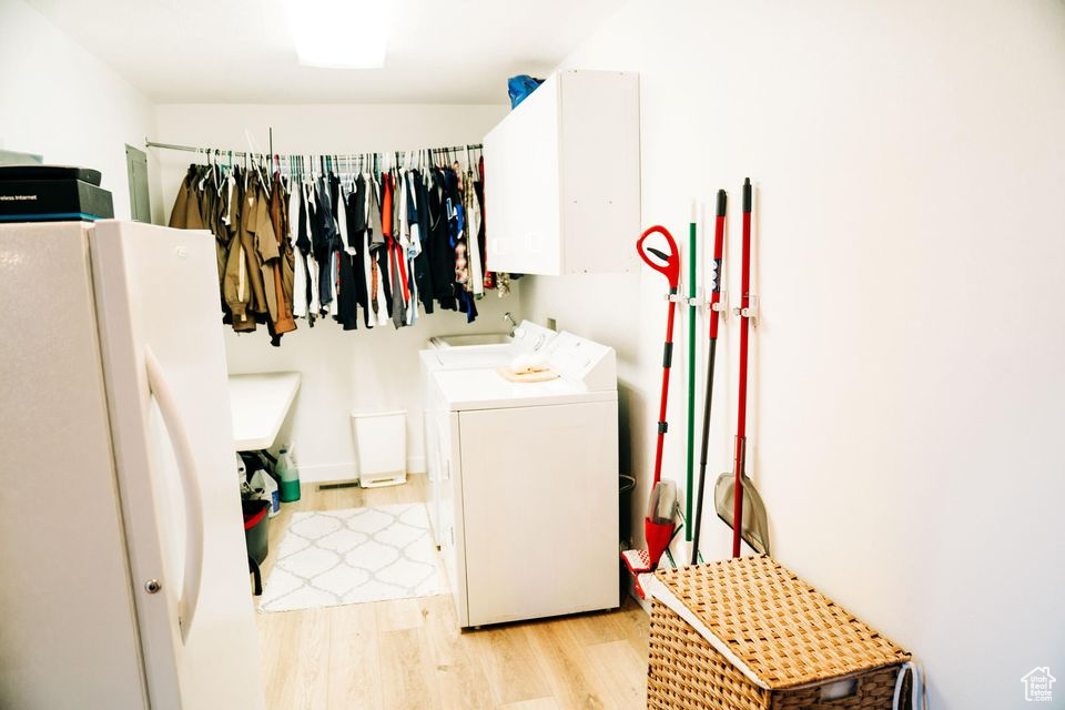 Laundry area featuring washer and dryer and light wood-style floors