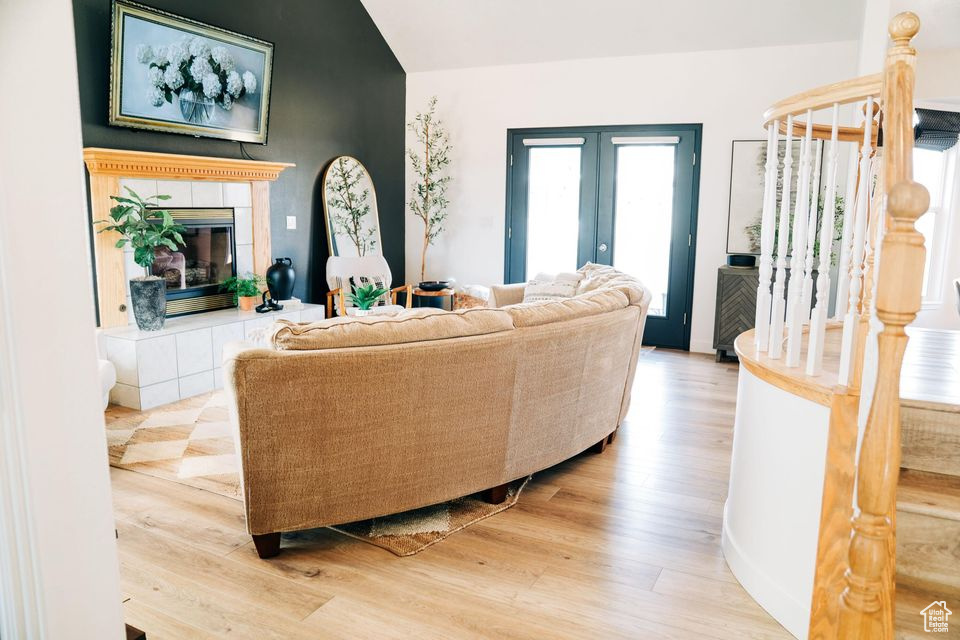 Living room with a fireplace, french doors, and wood finished floors