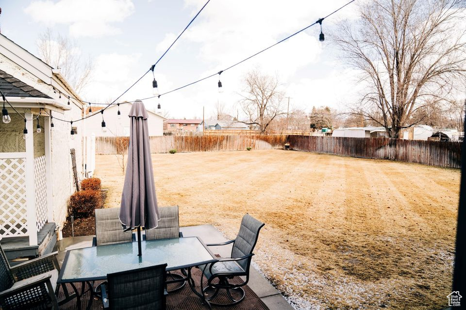 View of yard featuring a fenced backyard and outdoor dining space