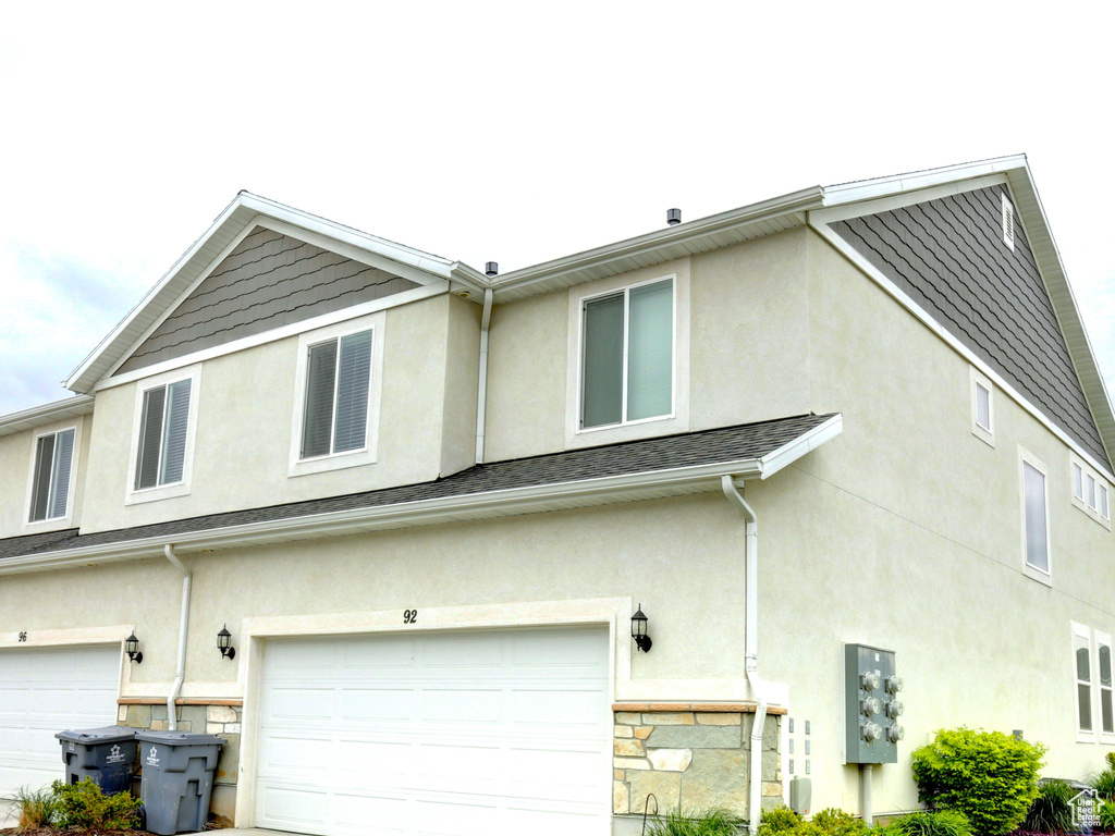 View of home\'s exterior with a lawn, stucco siding, a garage, and concrete driveway