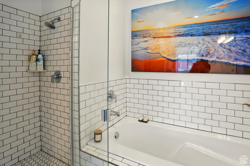 Full bathroom with a stall shower, a water view, and a garden tub