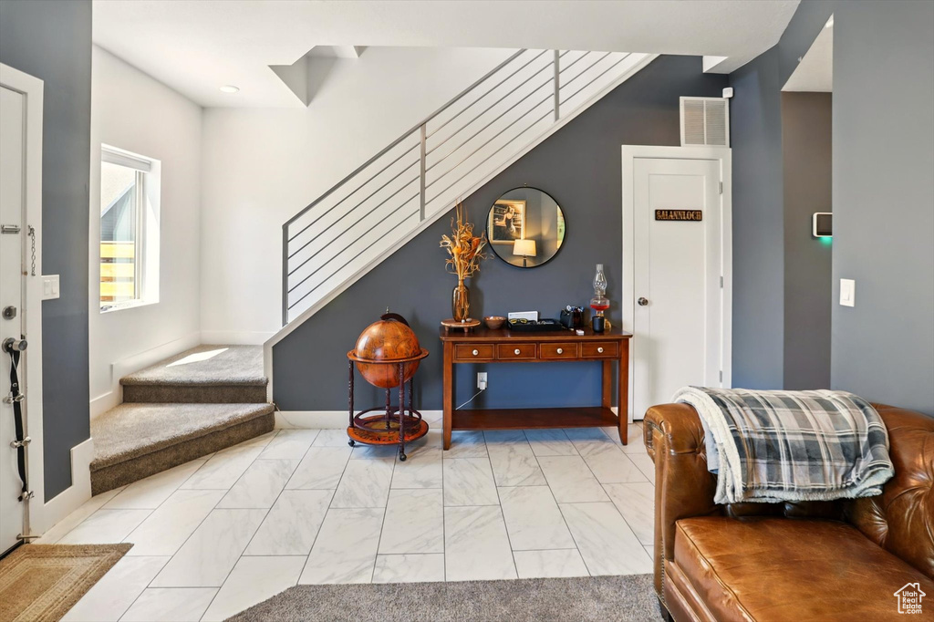 Foyer featuring marble finish floor, stairs, and visible vents