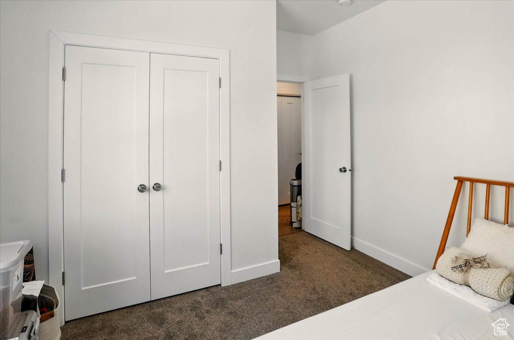 Carpeted bedroom featuring baseboards and a closet