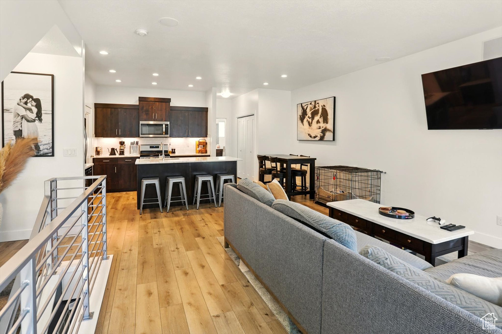 Living room featuring light wood-style floors, baseboards, and recessed lighting