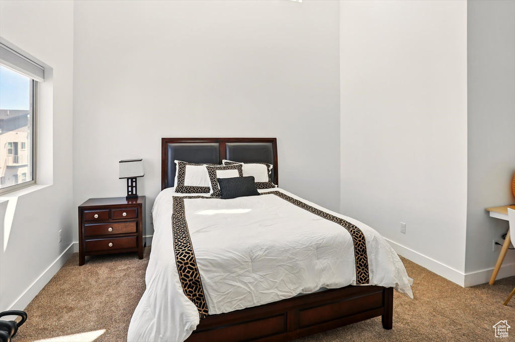 Bedroom featuring baseboards and carpet