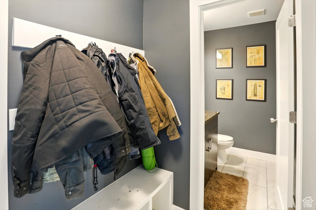 Bathroom featuring toilet, marble finish floor, vanity, visible vents, and baseboards