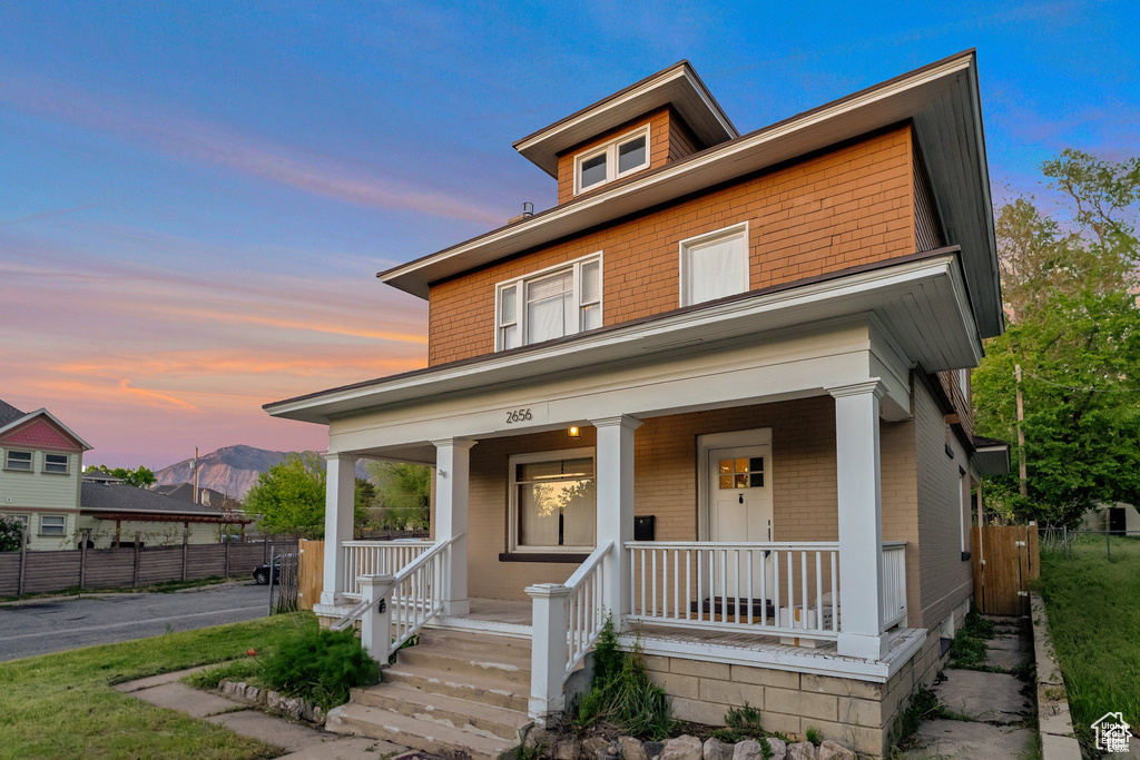 Traditional style home with a porch, fence, and a mountain view