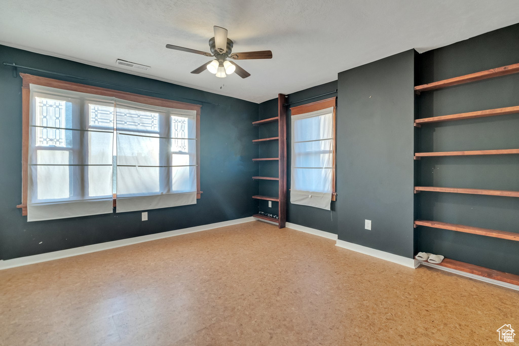 Spare room with visible vents, baseboards, and a ceiling fan