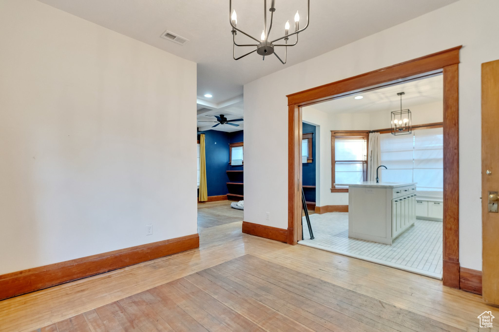 Interior space with ceiling fan with notable chandelier, light wood-type flooring, visible vents, baseboards, and recessed lighting