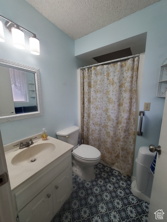 Bathroom with vanity, toilet, and a textured ceiling