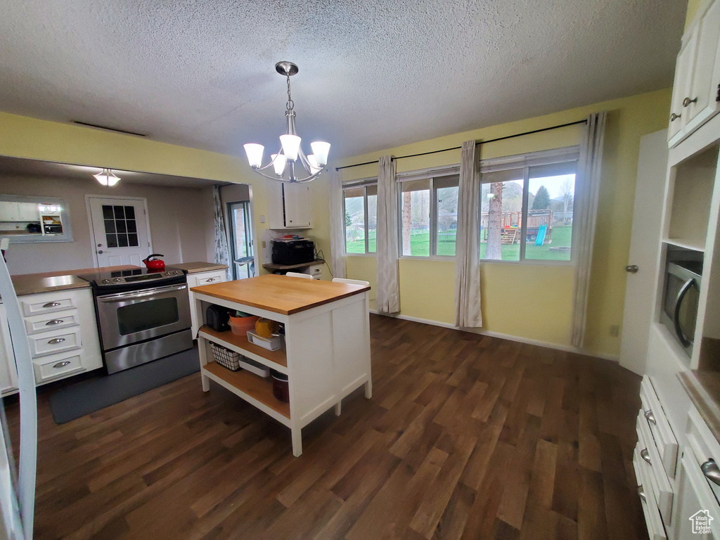 Kitchen with wooden counters, open shelves, white cabinetry, a textured ceiling, and electric stove