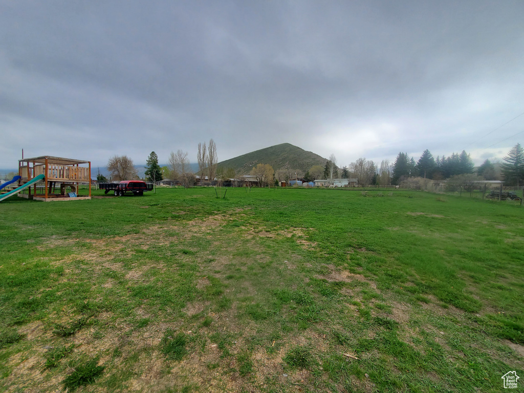 View of yard featuring a rural view, a mountain view, and playground community