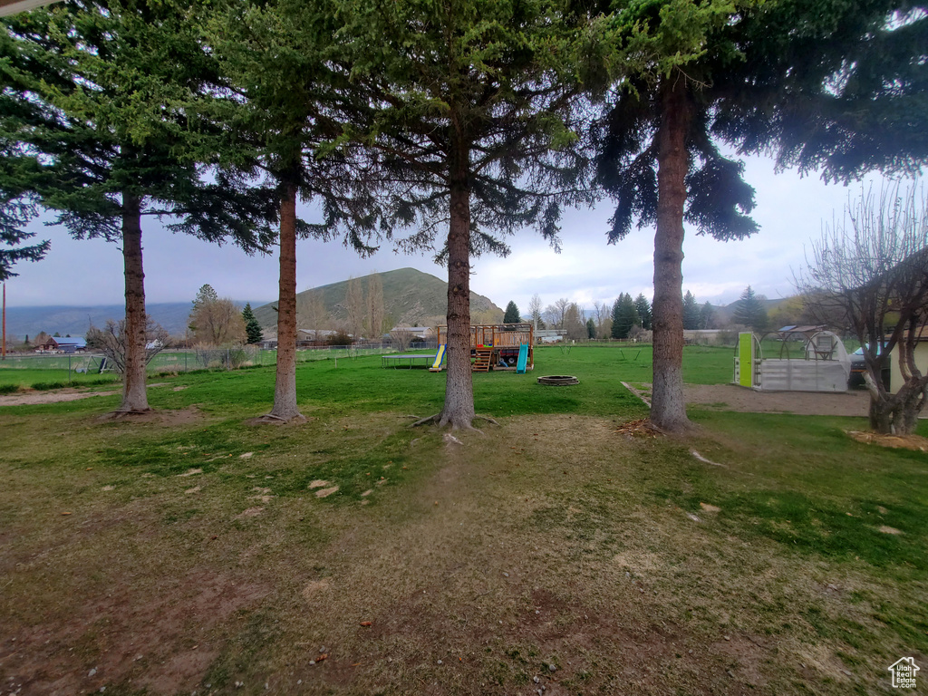View of yard with a mountain view and a playground