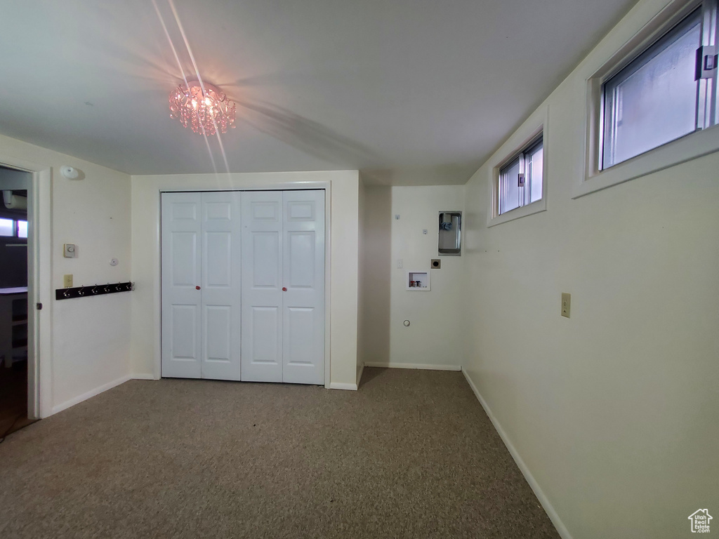 Unfurnished bedroom featuring carpet, baseboards, a closet, and a chandelier