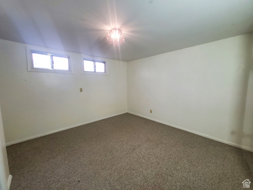 Unfurnished room with dark carpet and baseboards