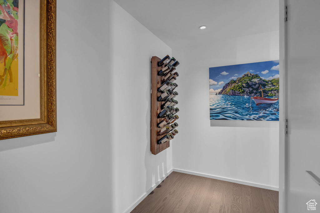 Corridor with baseboards, recessed lighting, and wood finished floors