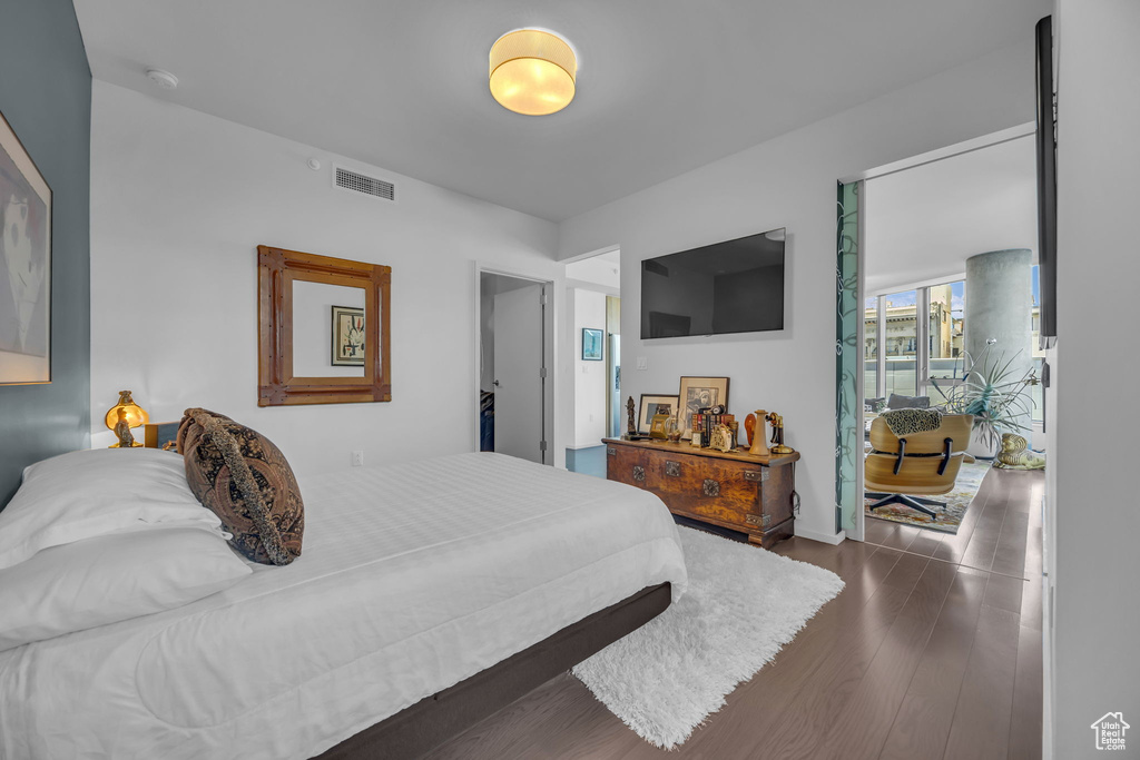 Bedroom featuring visible vents, baseboards, and dark wood-type flooring