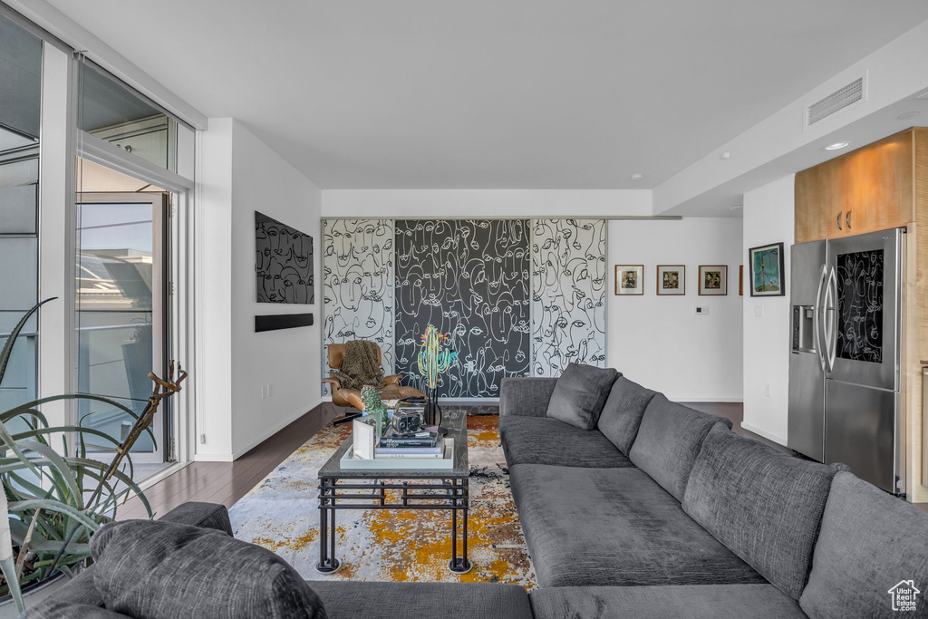 Living room featuring visible vents, wood finished floors, and baseboards