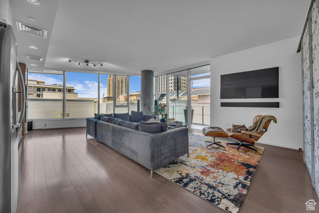 Living room featuring a wall of windows, visible vents, and wood finished floors