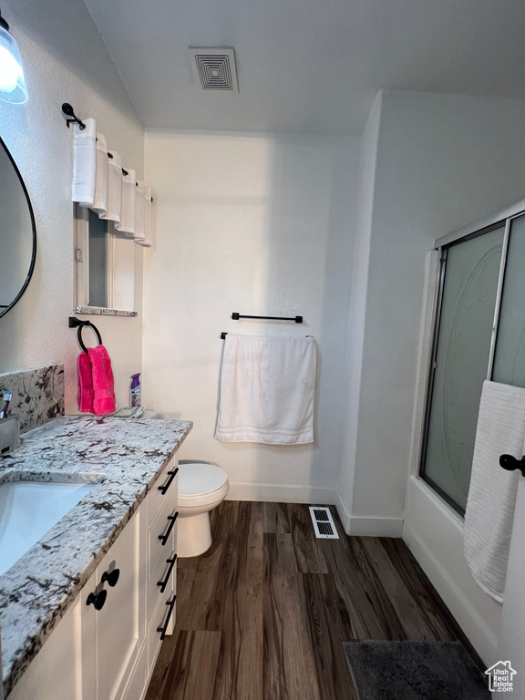 Full bathroom with baseboards, visible vents, wood finished floors, and vanity