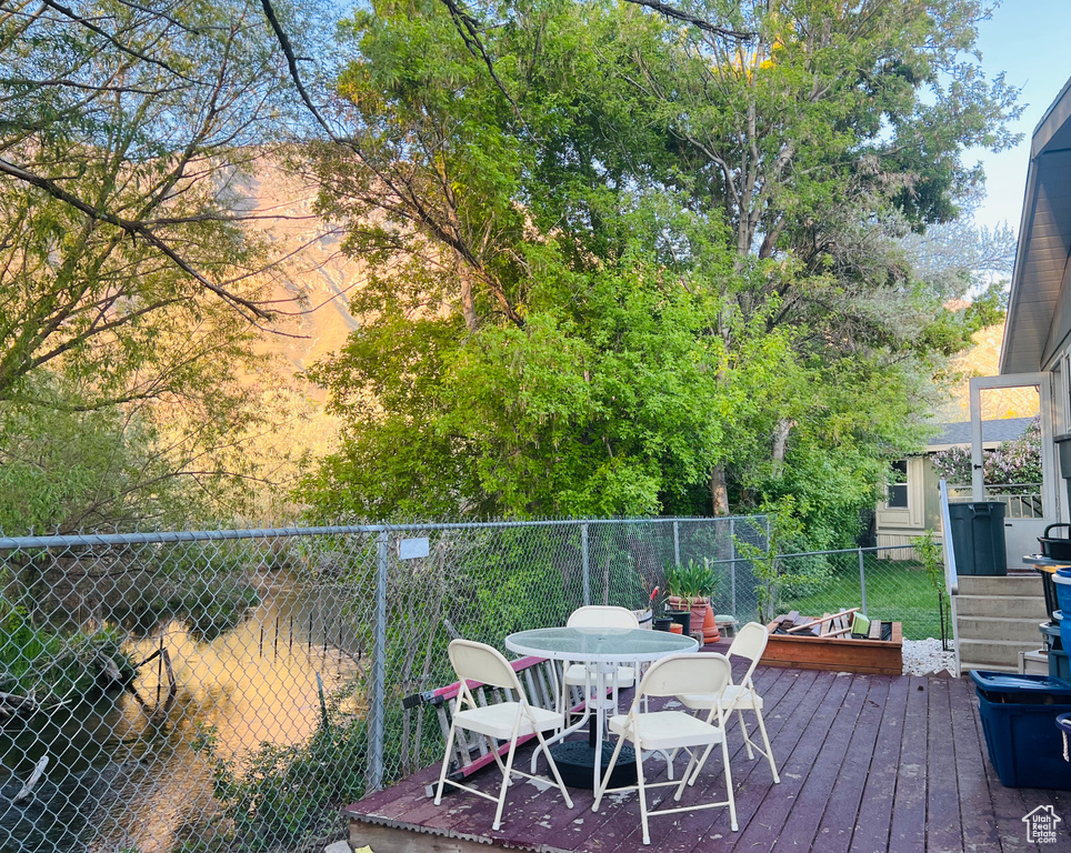 Wooden terrace featuring outdoor dining area and fence