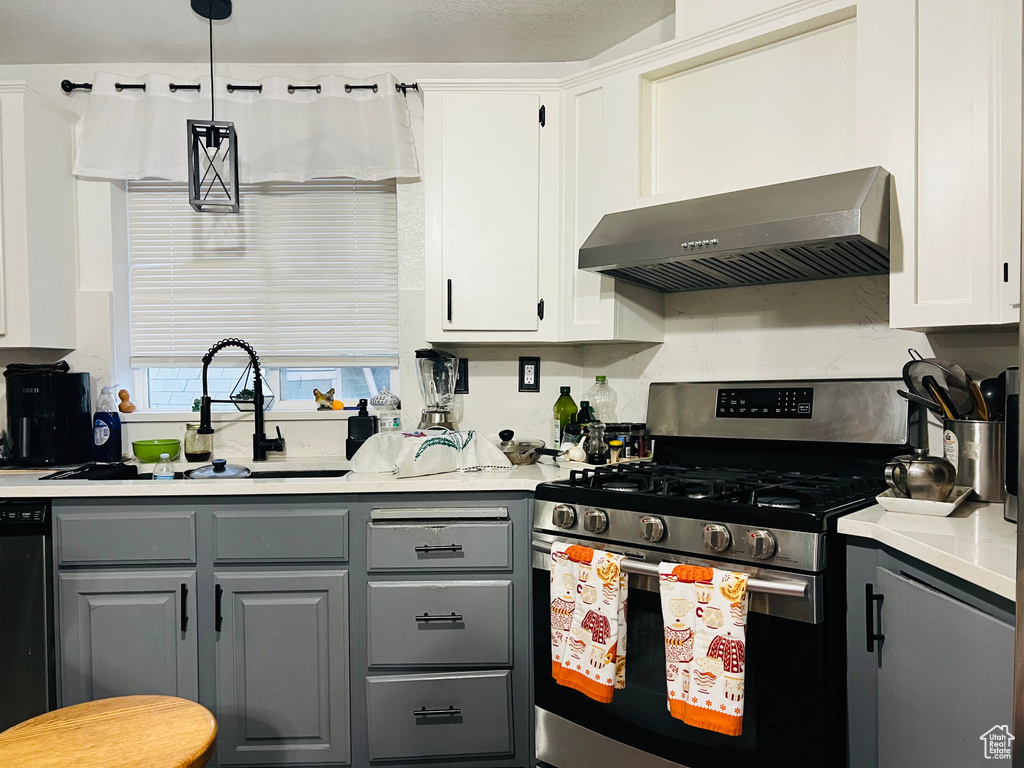 Kitchen with stainless steel range with gas cooktop, gray cabinetry, exhaust hood, and a sink