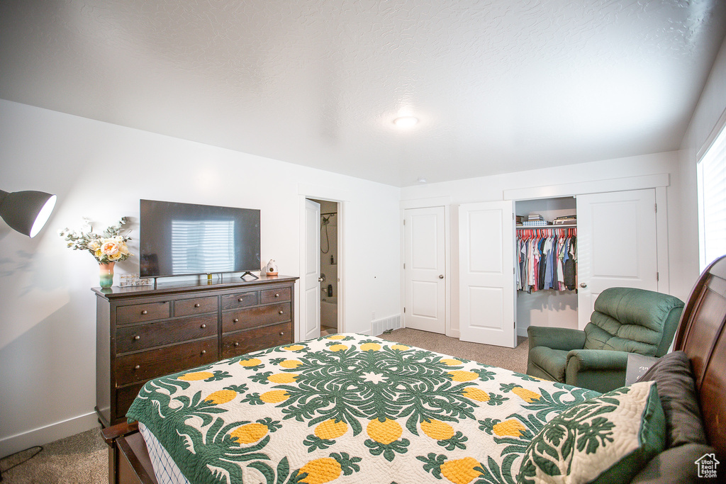 Carpeted bedroom with baseboards, a closet, and a walk in closet