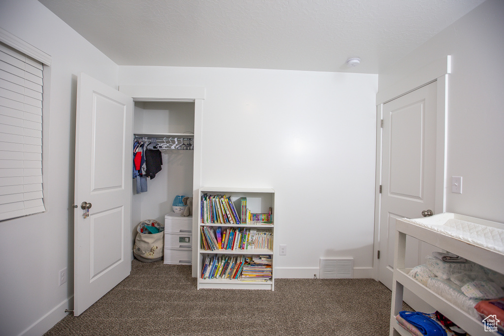 Bedroom featuring baseboards, a closet, visible vents, and carpet