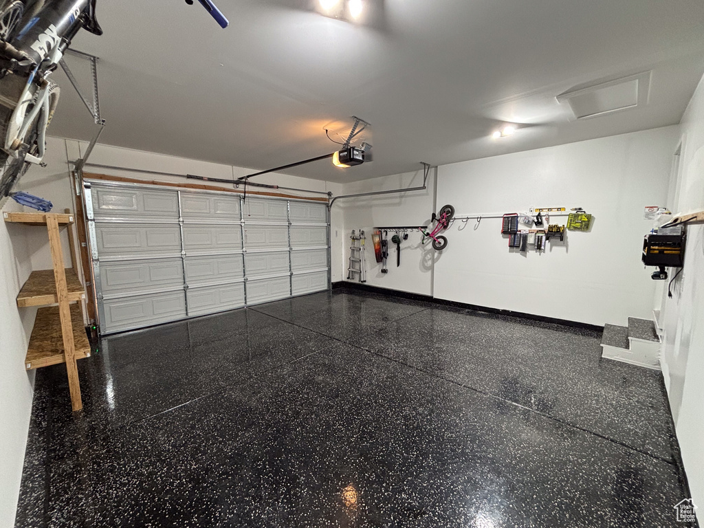 Garage featuring baseboards and a garage door opener