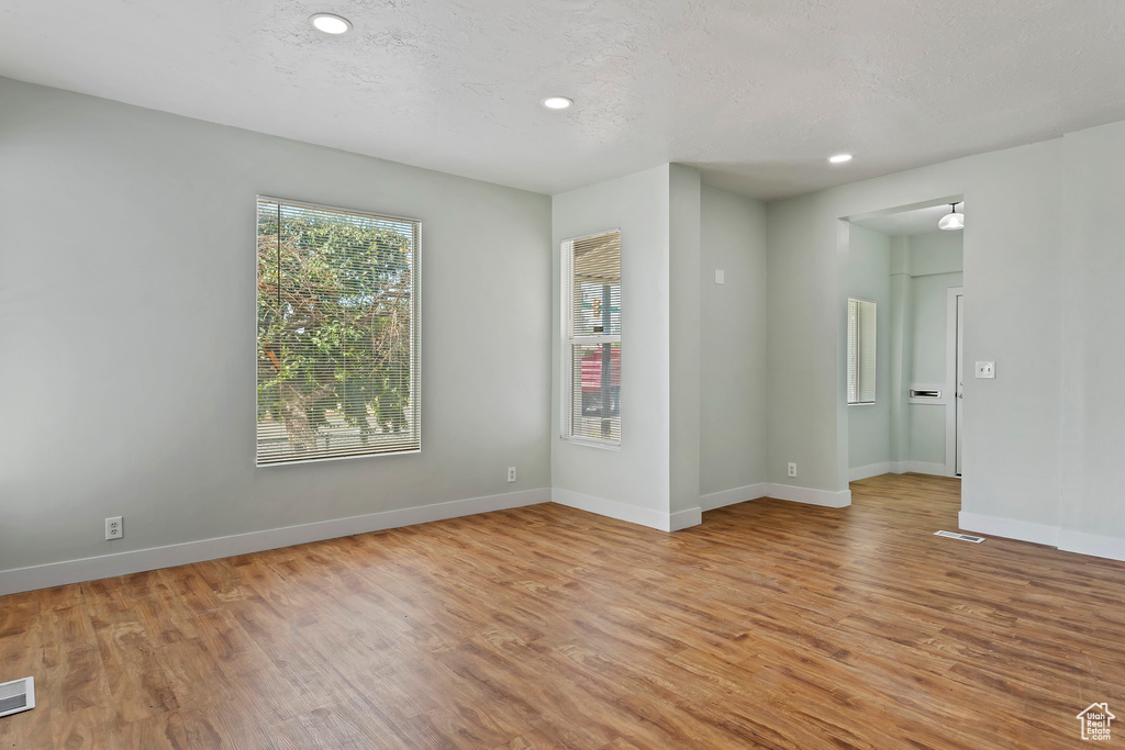 Unfurnished room with recessed lighting, baseboards, visible vents, and light wood-type flooring