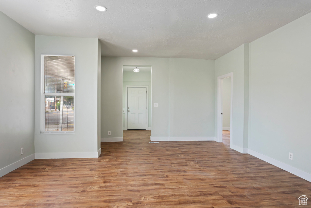Spare room with recessed lighting, baseboards, and wood finished floors