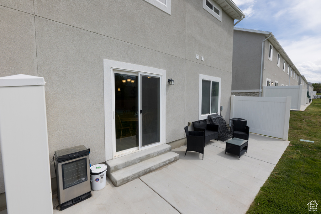 View of patio featuring entry steps, outdoor lounge area, heating unit, and fence