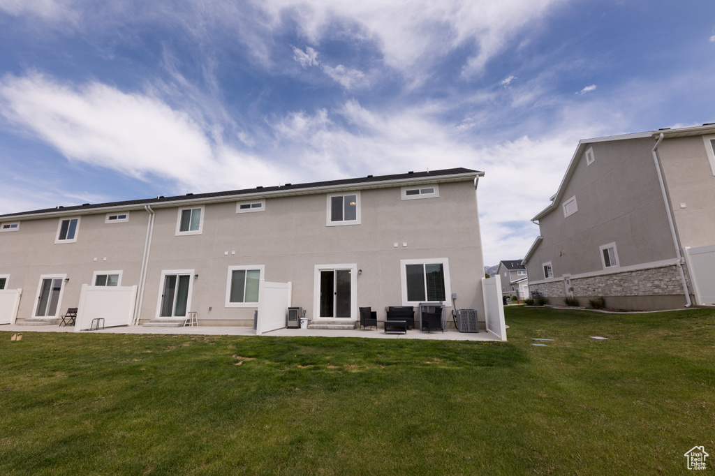 Back of house with a yard, an outdoor hangout area, a patio, and central air condition unit