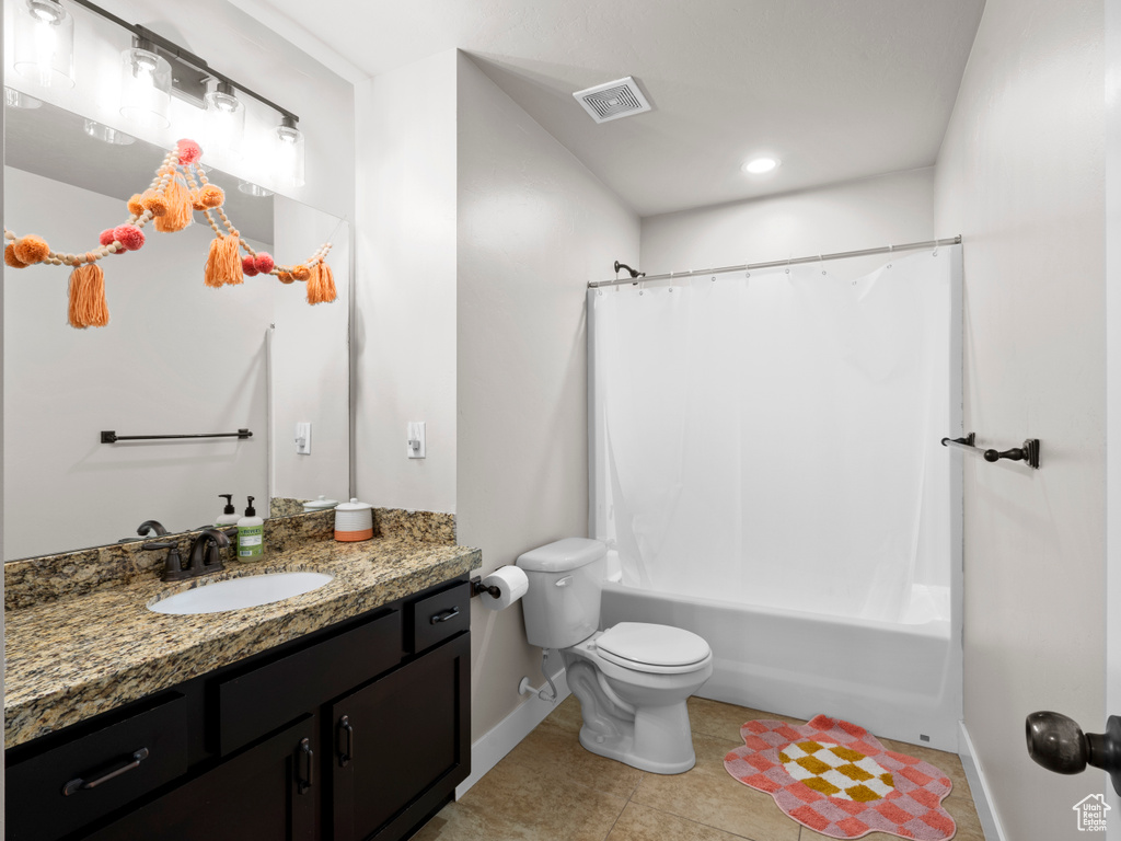 Bathroom featuring toilet, tile patterned floors, visible vents, baseboards, and vanity