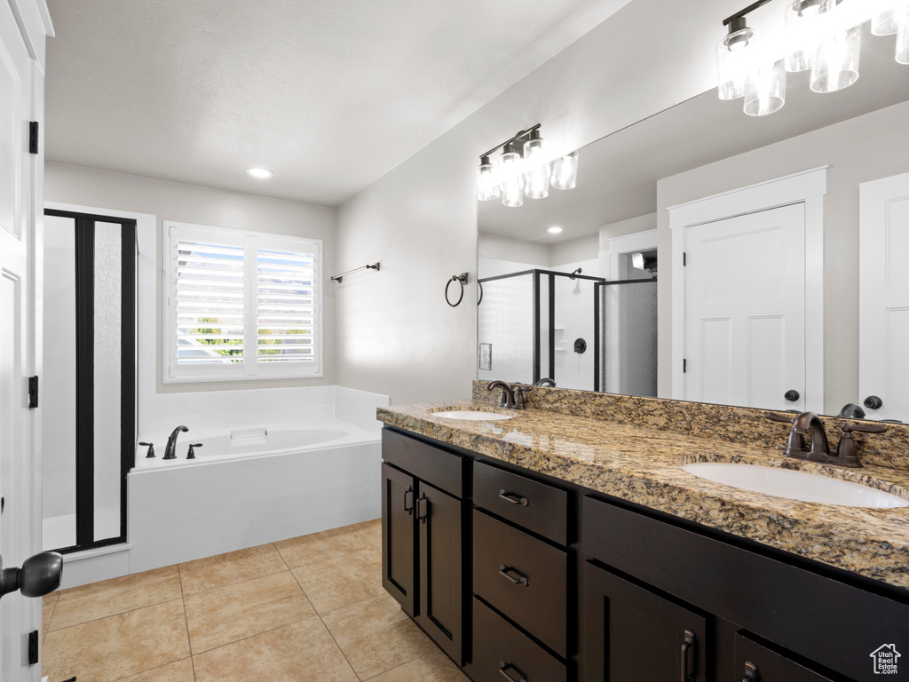 Bathroom featuring double vanity, a bath, a shower stall, and a sink