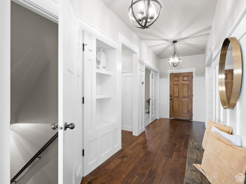 Interior space featuring dark wood-style flooring and a notable chandelier