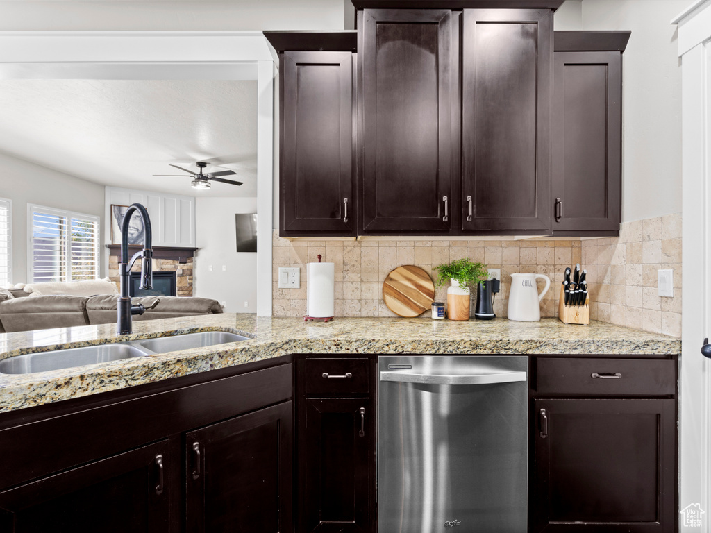 Kitchen featuring dark brown cabinets, a sink, stainless steel dishwasher, ceiling fan, and decorative backsplash